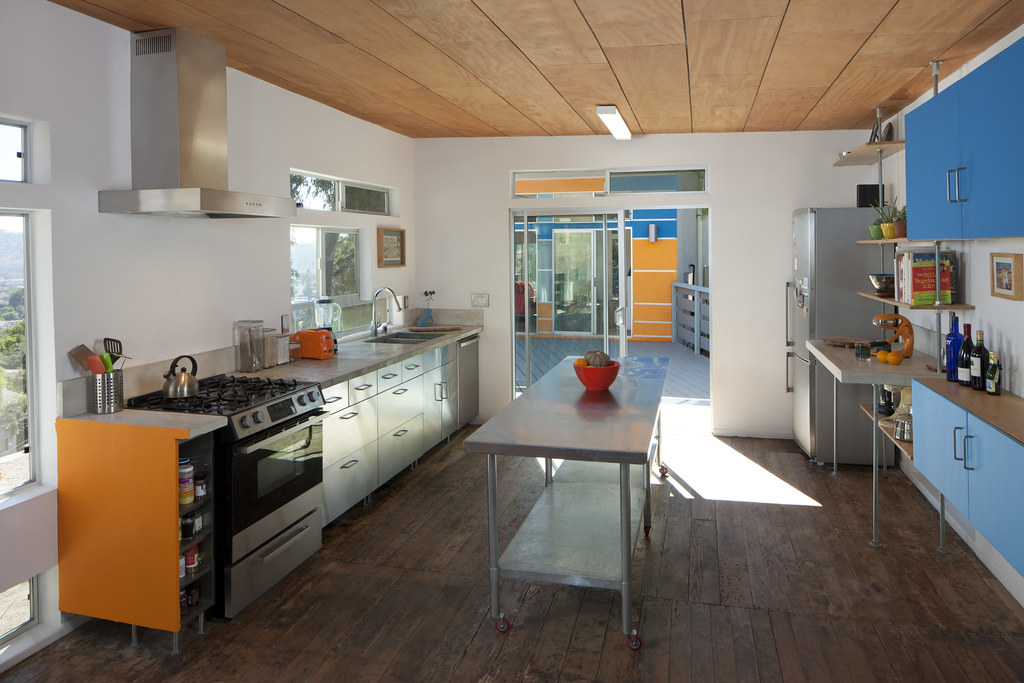 Modern kitchen with colorful cabinetry and wood ceiling